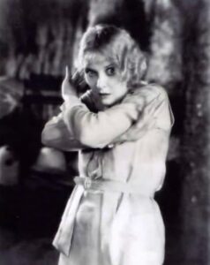 Mary Nolan clutching herself in distress in a still from the 1928 MGM film 'West of Zanzibar.'