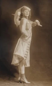 Mae Murray in costume with a parasol for the Ziegfeld Follies of 1915