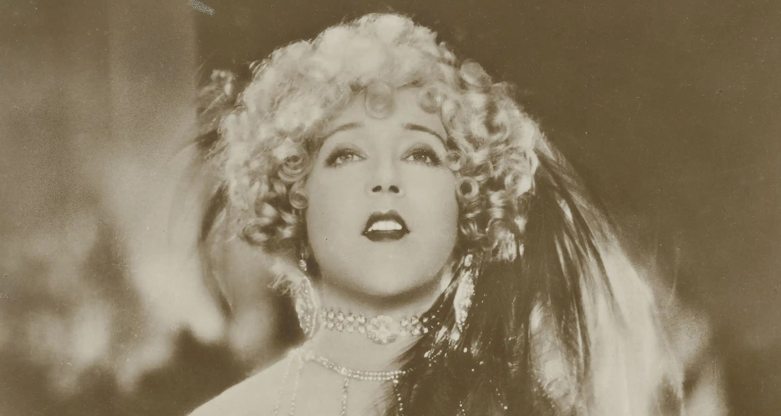 Portrait of silent film star Mae Murray with curled hair and a jeweled choker