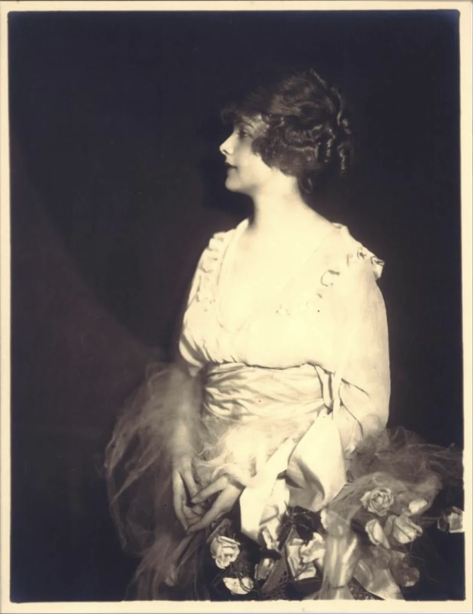 Marilyn Miller by Alfred Cheney Johnston, ca. 1919–20, in left profile with her hair worn up, holding roses; Middlebury College Museum of Art print