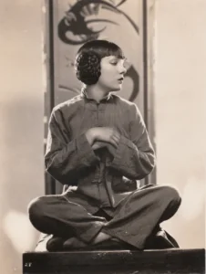 Lupe Velez in Chinese costume, sitting cross-legged, as Ming Toy in East Is West